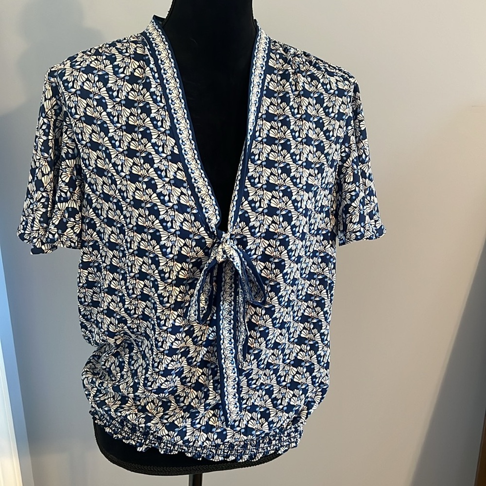 Light and airy ruffle sleeve short sleeve blouse. Deep b neck with self tie